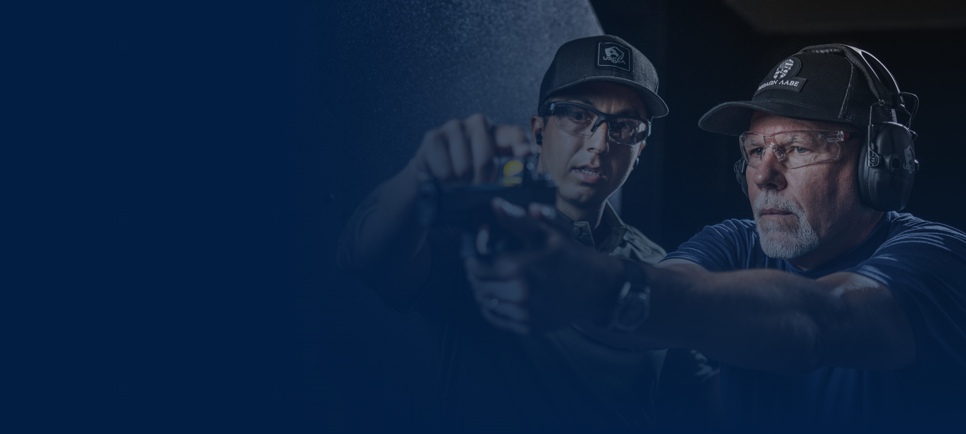 Instructor teaches student on proper gun handling at the range