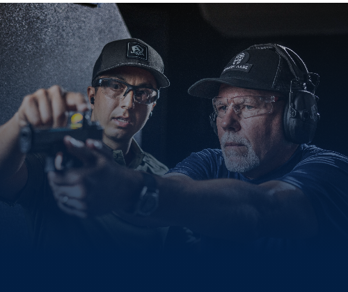 Instructor teaches student on proper gun handling at the range